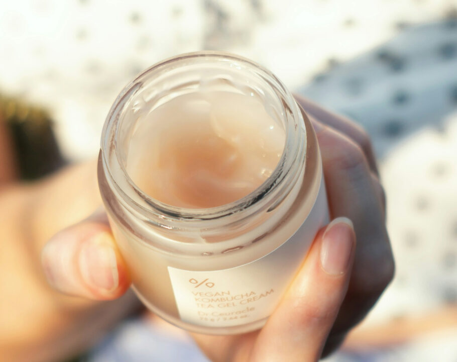 woman holding a jar of skin care cream