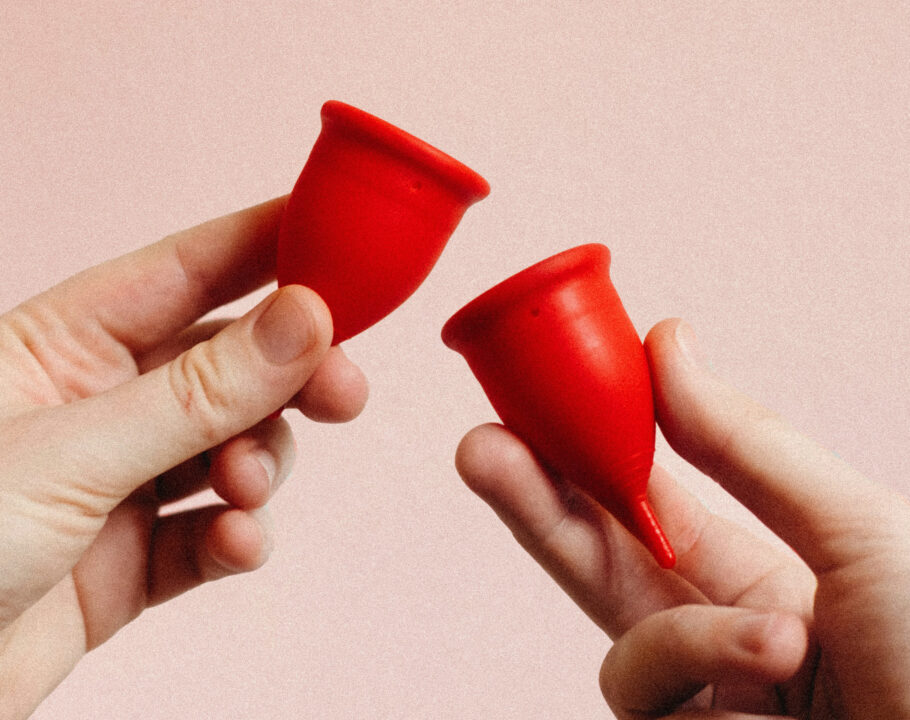 hands holding two red diva cups