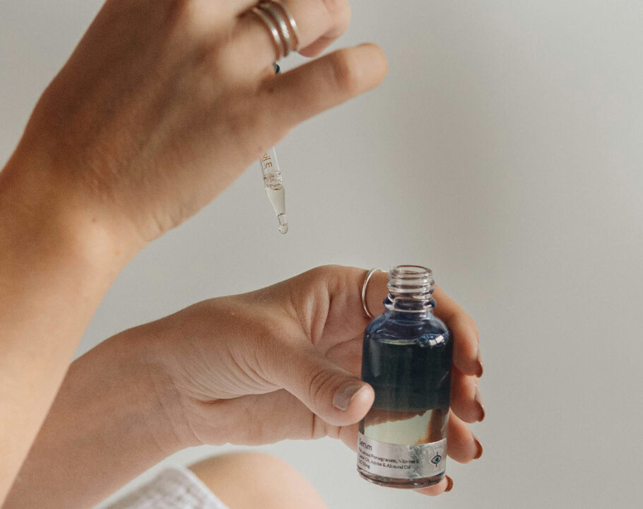 close up of woman putting skin serum on her hand