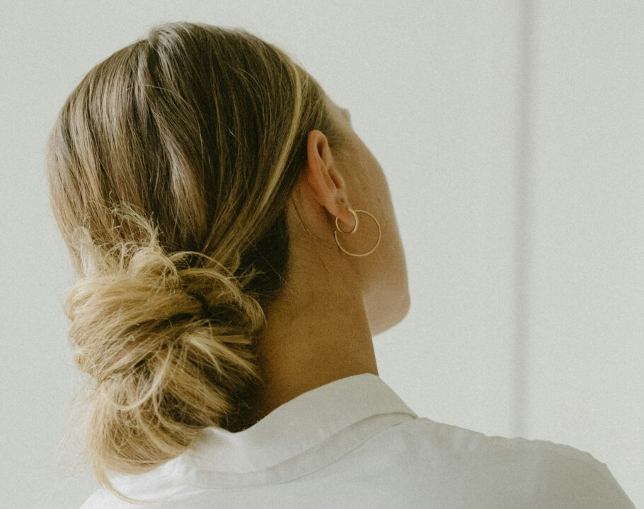 back view of woman with blonde hair in low bun