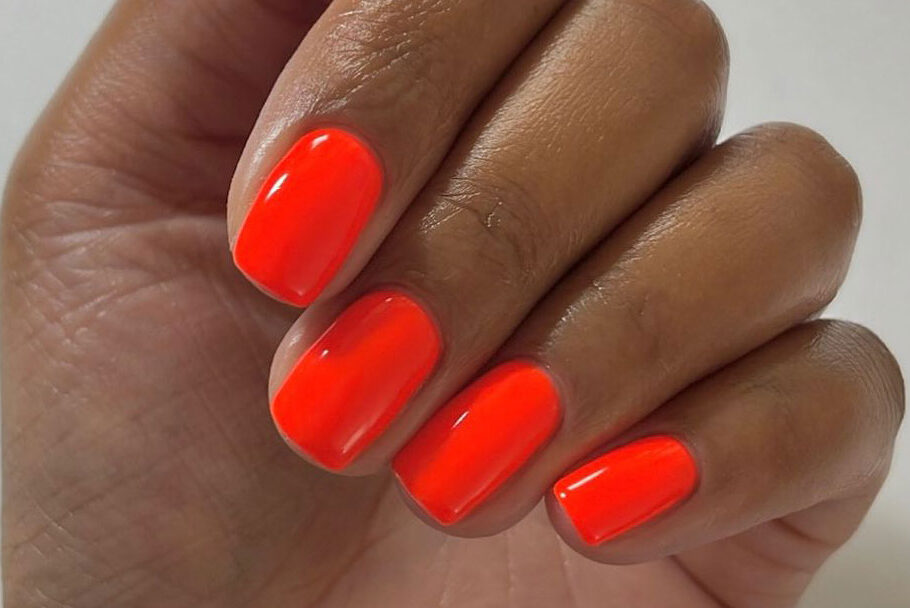 a close-up of short nails with bright red polish