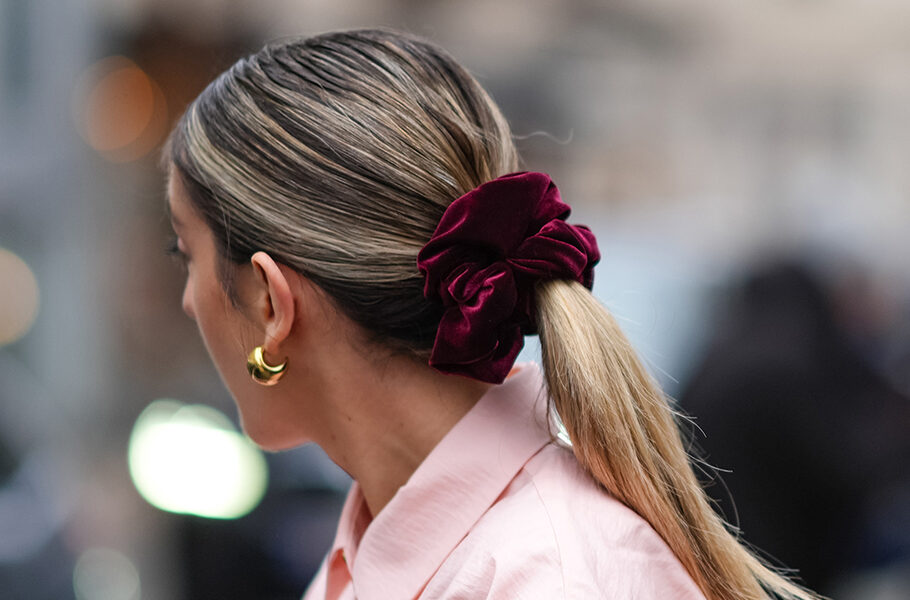 Close-up detail view of a sleek ponytail with purple hair scrunchie.